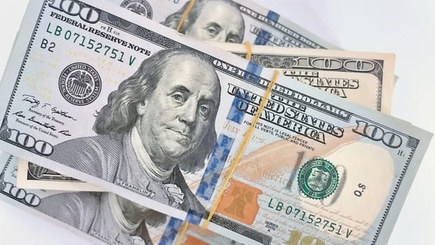 A Fan of $100 Bills.A close-up photo of a fan of $100 US dollar bills. The bills are arranged neatly, with the portrait of Benjamin Franklin visible on each bill. The background is white.Finance ve economy concept.
