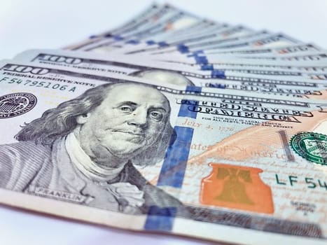 A Fan of $100 Bills.A close-up photo of a fan of $100 US dollar bills. The bills are arranged neatly, with the portrait of Benjamin Franklin visible on each bill. The background is white.Finance ve economy concept.