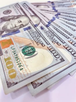 A Fan of $100 Bills.A close-up photo of a fan of $100 US dollar bills. The bills are arranged neatly, with the portrait of Benjamin Franklin visible on each bill. The background is white.Finance ve economy concept.