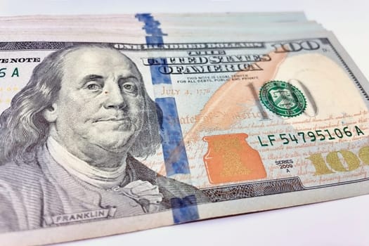 A Fan of $100 Bills.A close-up photo of a fan of $100 US dollar bills. The bills are arranged neatly, with the portrait of Benjamin Franklin visible on each bill. The background is white.Finance ve economy concept.