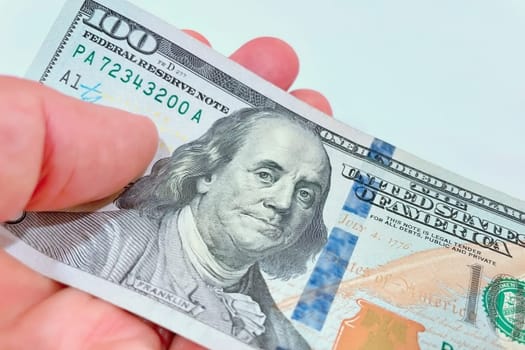 A Fan of $100 Bills.A close-up photo of a fan of $100 US dollar bills. The bills are arranged neatly, with the portrait of Benjamin Franklin visible on each bill. The background is white.Finance ve economy concept.