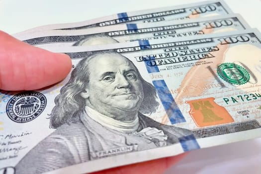 A Fan of $100 Bills.A close-up photo of a fan of $100 US dollar bills. The bills are arranged neatly, with the portrait of Benjamin Franklin visible on each bill. The background is white.Finance ve economy concept.