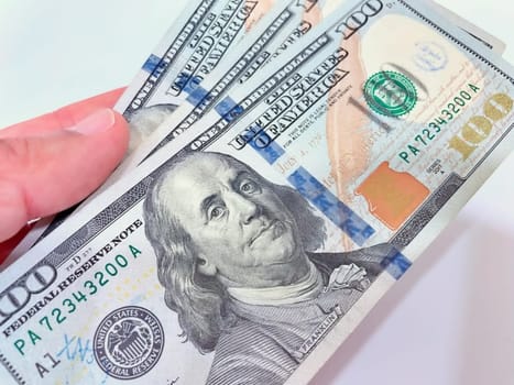 A Fan of $100 Bills.A close-up photo of a fan of $100 US dollar bills. The bills are arranged neatly, with the portrait of Benjamin Franklin visible on each bill. The background is white.Finance ve economy concept.