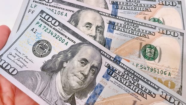 A Fan of $100 Bills.A close-up photo of a fan of $100 US dollar bills. The bills are arranged neatly, with the portrait of Benjamin Franklin visible on each bill. The background is white.Finance ve economy concept.