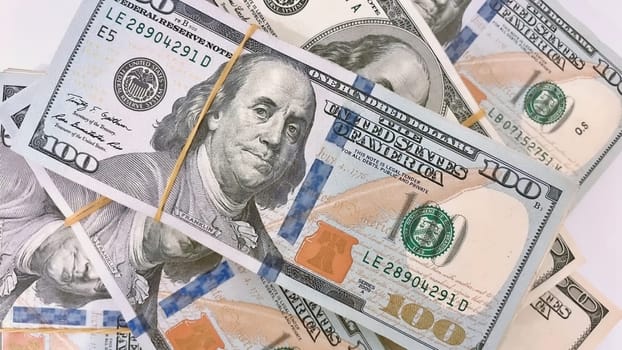 A Fan of $100 Bills.A close-up photo of a fan of $100 US dollar bills. The bills are arranged neatly, with the portrait of Benjamin Franklin visible on each bill. The background is white.Finance ve economy concept.