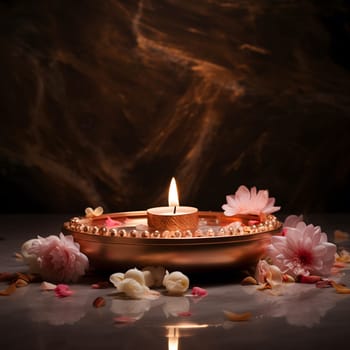 A single candle illuminates a bowl of water surrounded by delicate pink and white flowers, creating a peaceful and serene atmosphere.