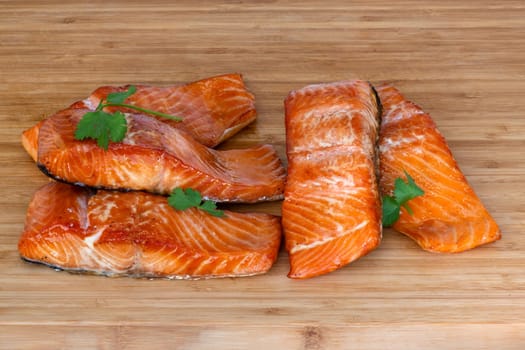Enjoy grilled salmon fillets garnished with lemon zest and herbs, elegantly served on a rustic cutting board