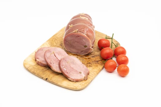 Baked Turkey roll with tomatoes on a wooden background.