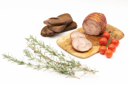 Smoked Turkey roll with herbs on a wooden background.