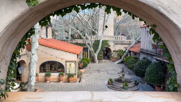 Sedona, Arizona, USA - 03.20.2024: A beautiful courtyard in Tlaquepaque Arts & Shopping Village in Sedona Arizona is seen through a charming archway. Tlaquepaque is a popular tourist destination.