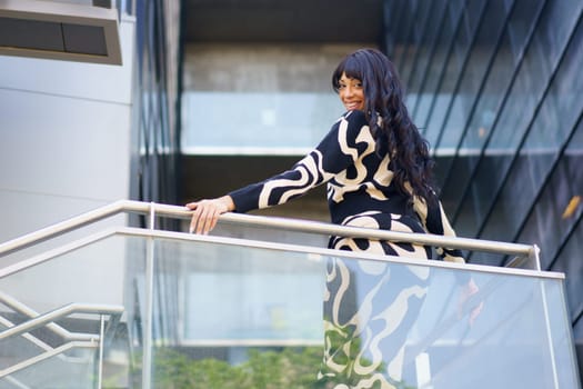 Sensual female hispanic dancer turning to look down from urban viewpoint of a building
