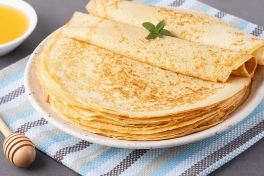 Stack of traditional russian pancakes blini on gray background with copy space. Homemade russian thin pancakes blini. Russian food, russian kitchen.