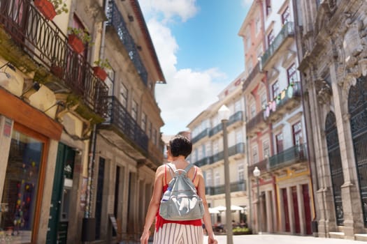 Woman walking through the streets of Porto on a sunny summer day, Portugal