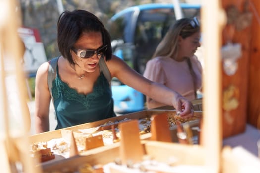 Woman looking at jewelry at a street market, Porto