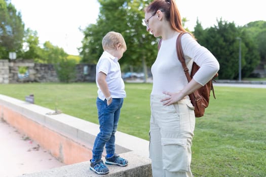 A woman and a child are standing in a park, day