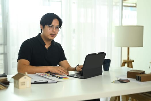 Interior designer working with a digital tablet or reviewing design project at office.