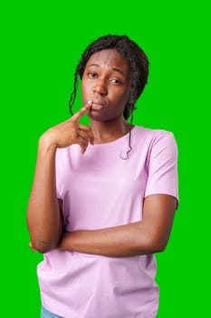 Thoughtful woman pondering in front of a bright green background during a casual moment close up