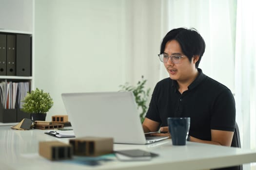 Handsome asian man working with interior design project at creative office.