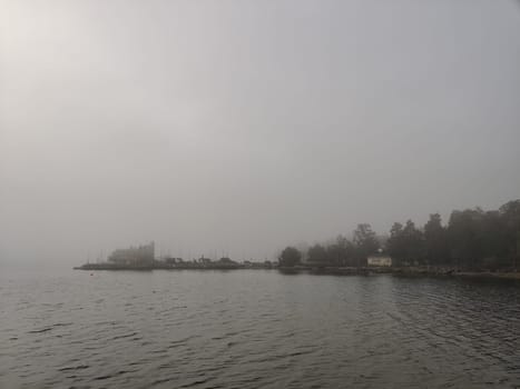 Relaxing foggy Northern autumn scene with swimming platform, pontoon or Wooden pier with a steel ladder into a Baltic sea. Autumn holiday vacation in Finland with beautiful sea