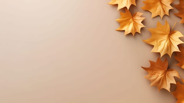 Golden fall leaves arranged on a beige background. Simple minimalist design for autumn.