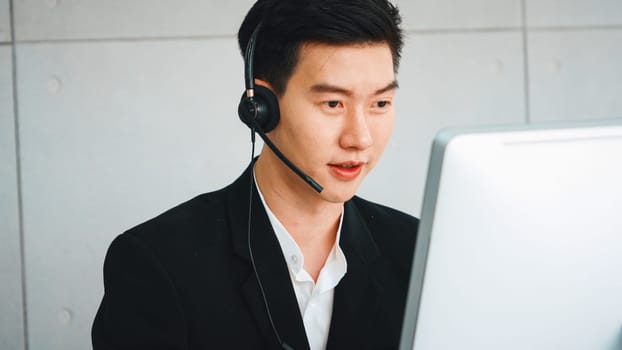 Business people wearing headset working in office to support remote customer or colleague. Call center, telemarketing, customer support agent provide service on telephone video conference call. Jivy