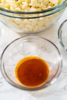 Measured ingredients in glass mixing bowls to make white chocolate ganache frosting.