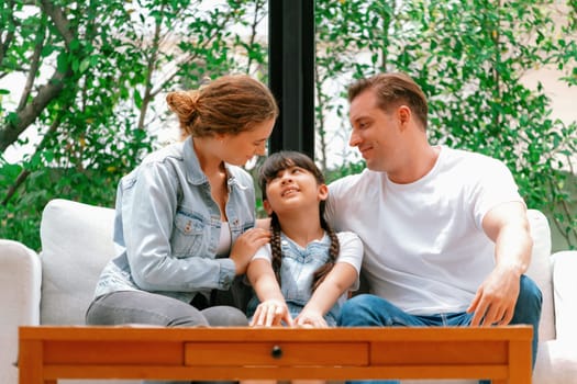 Parents comforting their daughter with loving hug, helping her feel secure and protected from fear, rest her head on shoulder. Happy family love and child care support concept. Synchronos