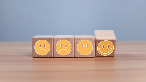 Mental health and emotional state concept, Smile face  and sad face on wooden block cube for positive mindset selection concept.