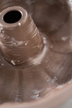 Greasing metal bundt cake pan to red velvet bundt cake with cream cheese glaze.