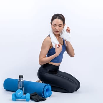 Athletic and sporty asian woman resting after intensive cardio workout training. Healthy exercising and fit body care lifestyle pursuit in studio shot isolated background. Vigorous