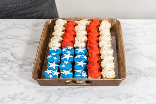 Arranging mini vanilla cupcakes in the shape of the American flag.