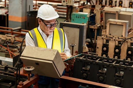 Factory engineer manager conduct inspection of industrial steel forming machine, exemplifying leadership as metalwork machinery engineering inspection supervisor in the facility.