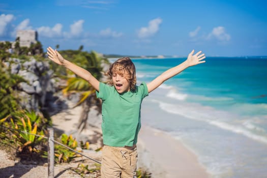 Boy tourist enjoying the view Pre-Columbian Mayan walled city of Tulum, Quintana Roo, Mexico, North America, Tulum, Mexico. El Castillo - castle the Mayan city of Tulum main temple.