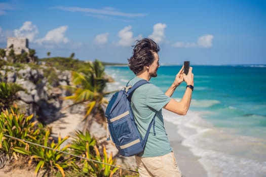 Male tourist enjoying the view Pre-Columbian Mayan walled city of Tulum, Quintana Roo, Mexico, North America, Tulum, Mexico. El Castillo - castle the Mayan city of Tulum main temple.