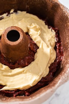 Filling metal bundt cake pan with cake butter to bake red velvet bundt cake with cream cheese glaze