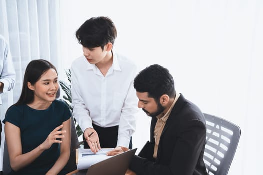 Professional Asian employee work together as team in corporate office, discussing business plans and data to achieve success on desk with laptop. Modern office worker teamwork concept. Concord