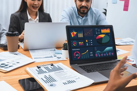 Multiracial analyst team use BI Fintech software to analyze financial data on meeting table. Financial dashboard data display on laptop screen with analyzed chart for marketing indication. Concord