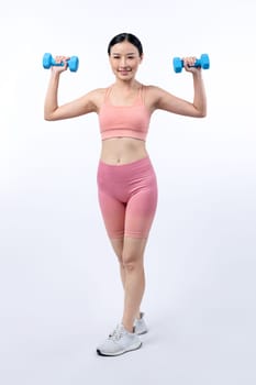 Vigorous energetic woman doing dumbbell weight lifting exercise on isolated background. Young athletic asian woman strength and endurance training session as body workout routine.