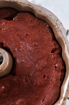 Cooling freshly baked red velvet bundt cake on a kitchen counter.