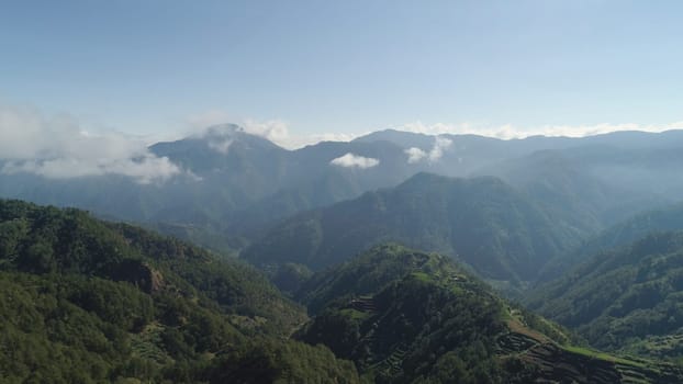 Aerial view of rice terraces and agricultural land on the slopes of the mountains. Mountains covered forest, trees. Cordillera region. Luzon, Philippines.