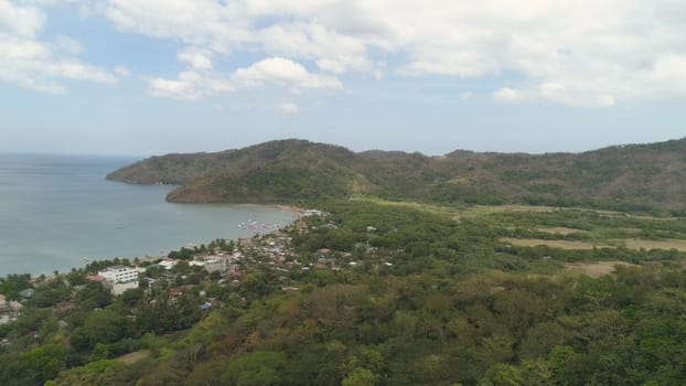 Aerial view of coast with beach in blue lagoon. Philippines, Luzon. Coast ocean with tropical beach, turquoise water. Tropical landscape in Asia.