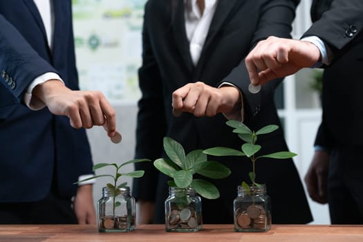 Business people put money saving into jar filled with coins and growing plant for sustainable financial planning for retirement or eco subsidy investment for environment protection. Quaint