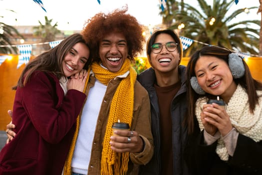 Happy and cheerful multiracial group of college student friends looking at camera smiling on a sunny winter day outdoors.Lifestyle portrait concept.