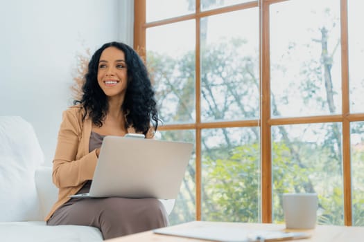 African-American woman using laptop computer for crucial work on internet. Secretary or online content writing working at home.