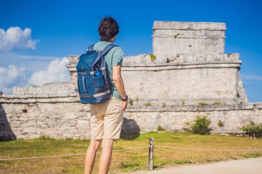 Male tourist enjoying the view Pre-Columbian Mayan walled city of Tulum, Quintana Roo, Mexico, North America, Tulum, Mexico. El Castillo - castle the Mayan city of Tulum main temple.