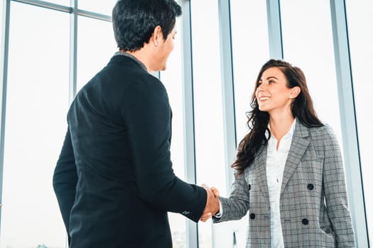 Business people handshake in corporate office showing professional agreement on a financial deal contract. Jivy