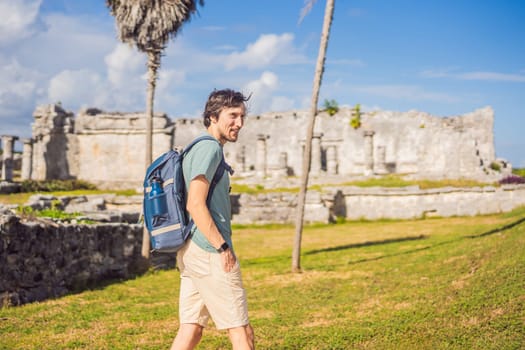 Male tourist enjoying the view Pre-Columbian Mayan walled city of Tulum, Quintana Roo, Mexico, North America, Tulum, Mexico. El Castillo - castle the Mayan city of Tulum main temple.