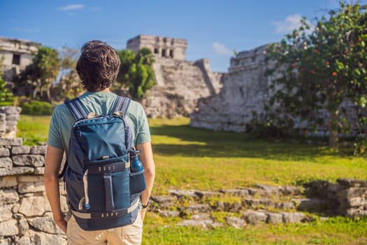 Male tourist enjoying the view Pre-Columbian Mayan walled city of Tulum, Quintana Roo, Mexico, North America, Tulum, Mexico. El Castillo - castle the Mayan city of Tulum main temple.