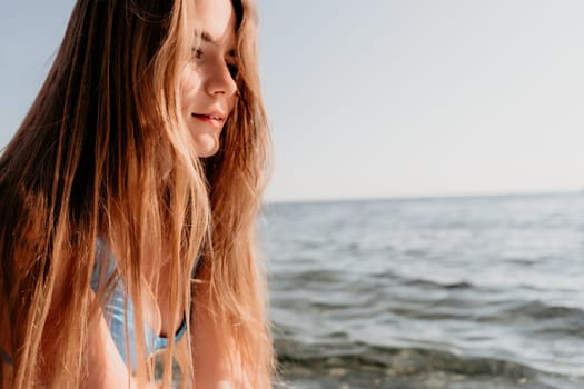 Close up shot of happy young caucasian woman looking at camera and smiling. Cute woman portrait in bikini posing on a volcanic rock high above the sea