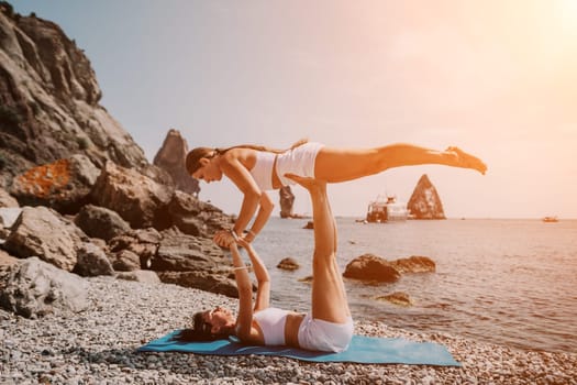 Woman sea yoga. Back view of free calm happy satisfied woman with long hair standing on top rock with yoga position against of sky by the sea. Healthy lifestyle outdoors in nature, fitness concept.